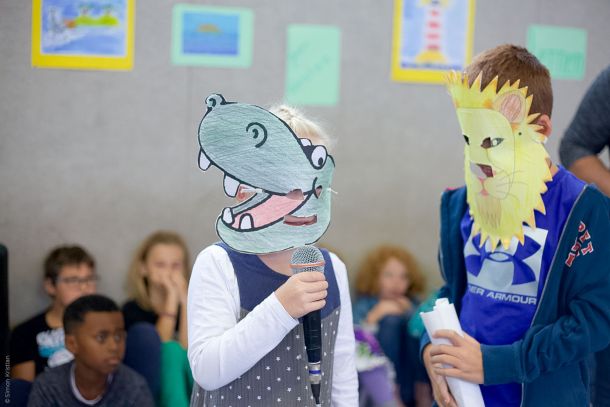 Grundschüler mit Papiermasken