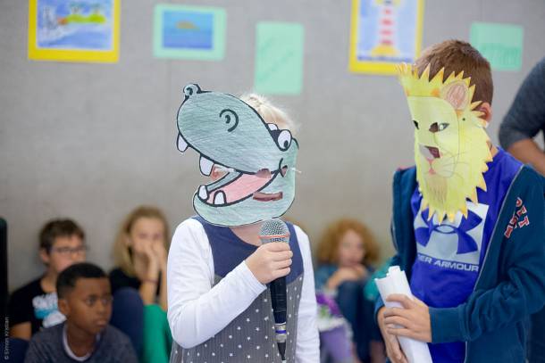 Grundschüler mit Papiermasken